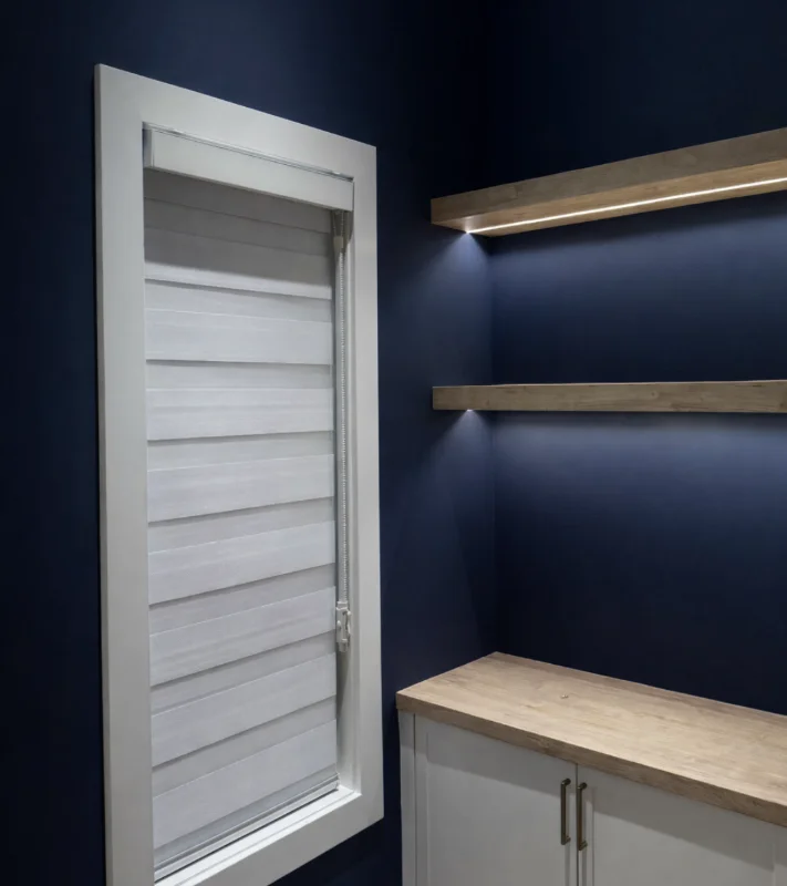 Zebra shade in a navy bar nook with floating oak shelves